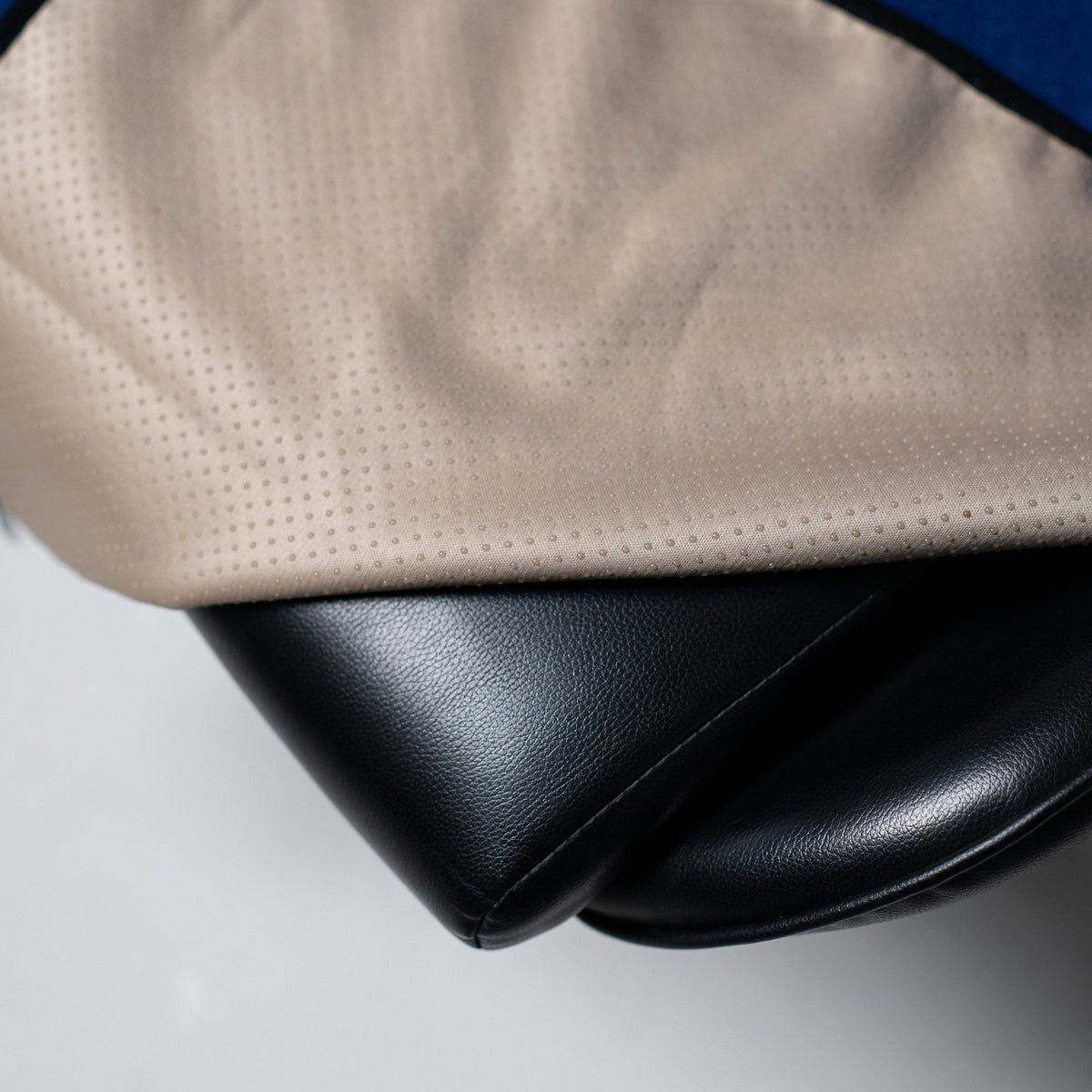 Close-up of a waterproof seat cover's non-slip backing against a leather car seat